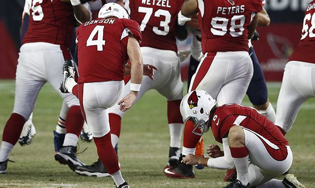 Arizona Cardinals kicker Phil Dawson (4) attempts a field goal as punter Matt Wile (6) holds during...