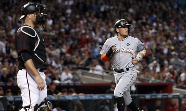 Miami Marlins' Miguel Rojas scores on a hit by Dee Gordon as Arizona Diamondbacks catcher Chris Ian...
