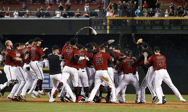 Arizona Diamondbacks players celebrate a walk off single by J.D. Martinez as they clinch a National...
