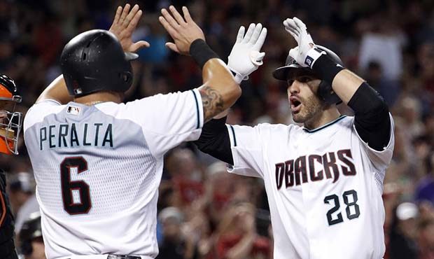 Arizona Diamondbacks' J.D. Martinez (28) high-fives David Peralta (6) after hitting a grand slam ag...