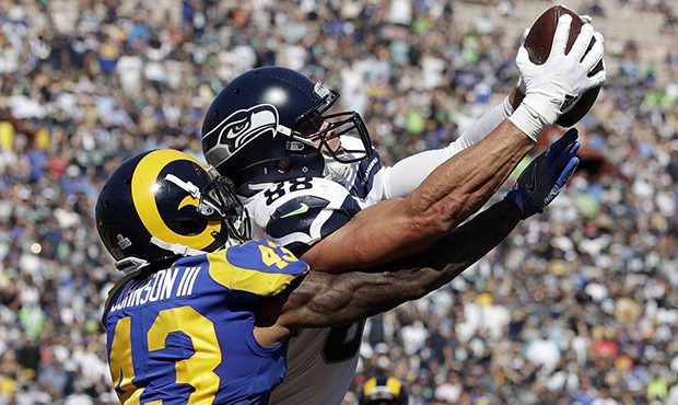 Seattle Seahawks tight end Jimmy Graham catches a touchdown pass under pressure from Los Angeles Ra...