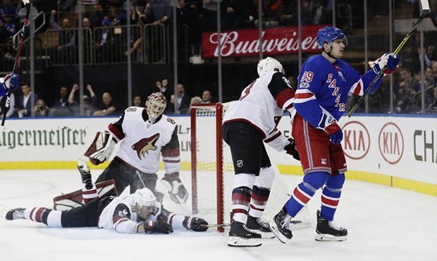 Arizona Coyotes goalie Adin Hill, above left, Adam Clendening, below left, and Alex Goligoski react...