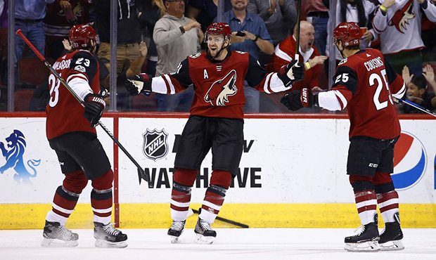 Arizona Coyotes center Derek Stepan, middle, celebrates his goal against the Dallas Stars with Coyo...