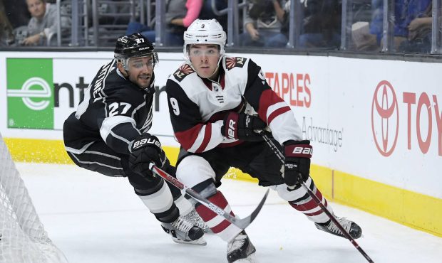 Los Angeles Kings defenseman Alec Martinez, left, reaches in on Arizona Coyotes center Clayton Kell...