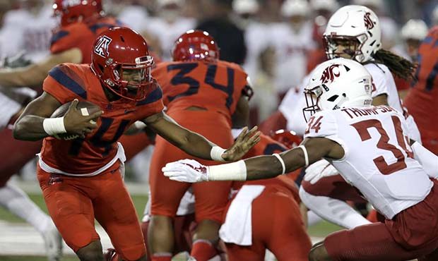 Arizona quarterback Khalil Tate (14) stiff-arms Washington State safety Jalen Thompson (34) in the ...