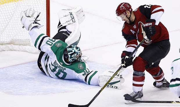Dallas Stars goalie Ben Bishop (30) makes a sliding save as Arizona Coyotes center Derek Stepan, ri...