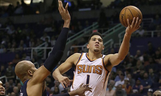 Phoenix Suns guard Devin Booker (1) drives on Minnesota Timberwolves forward Taj Gibson in the seco...