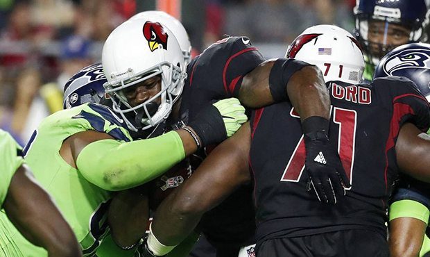 Arizona Cardinals running back Adrian Peterson, center, is stopped in the end zone by the Seattle S...