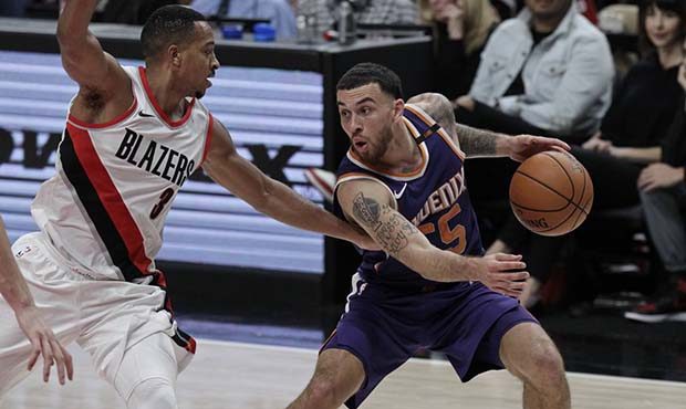 Phoenix Suns guard Mike James, right, handles the ball as Portland Trail Blazers guard CJ McCollum ...