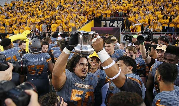 Arizona State players hold the Territorial Cup after an NCAA college football game against Arizona,...
