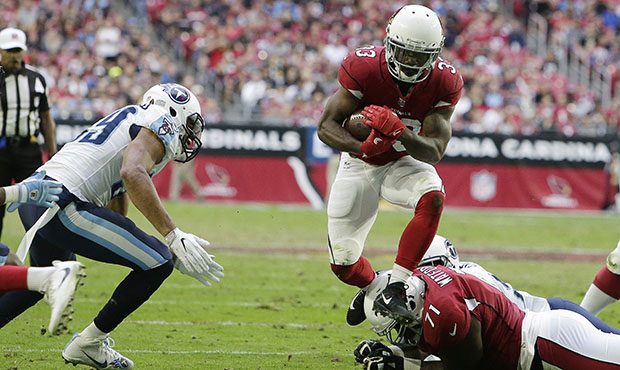 Arizona Cardinals running back Kerwynn Williams (33) jumps over Cardinals offensive guard Earl Watf...