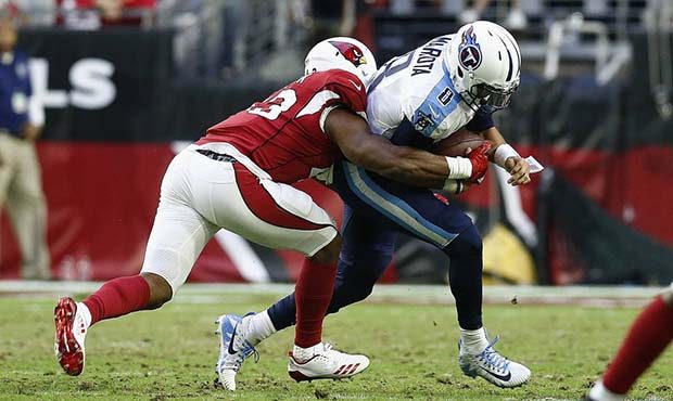 Arizona Cardinals inside linebacker Haason Reddick, left, brings down Tennessee Titans quarterback ...