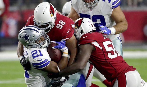 Dallas Cowboys running back Ezekiel Elliott (21) is hit by Arizona Cardinals nose tackle Corey Pete...