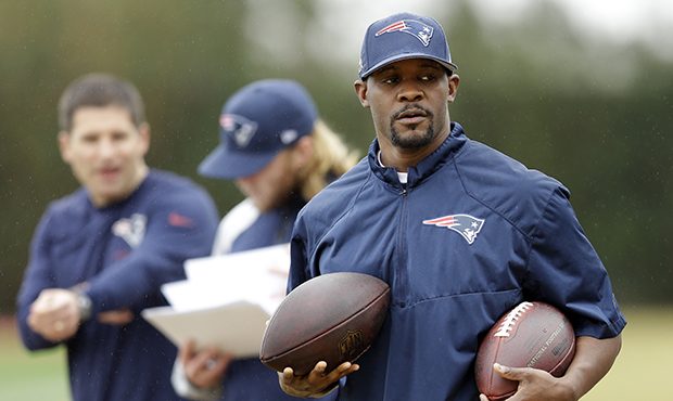 New England Patriots safeties coach Brian Flores, right, walks on the sideline during practice Frid...