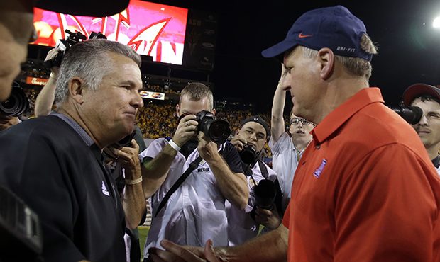 Arizona State head coach Todd Graham, left, and Arizona head coach Rich Rodriguez shake hands after...