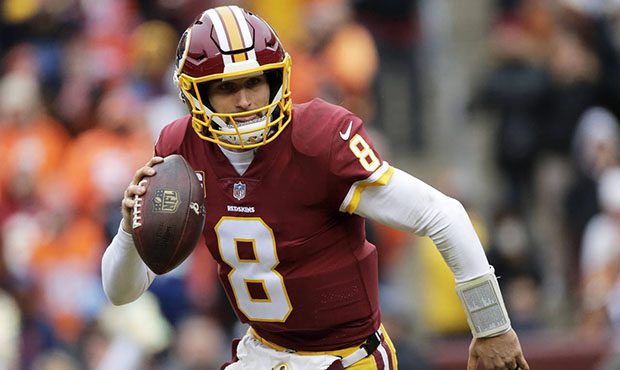 This Dec. 24, 2017, file photo shows Washington Redskins quarterback Kirk Cousins scrambling during...