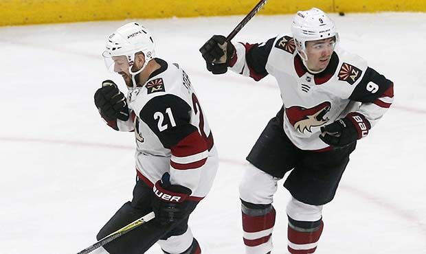 Arizona Coyotes' Derek Stepan, left, celebrates the winning goal in overtime by Clayton Keller, rig...