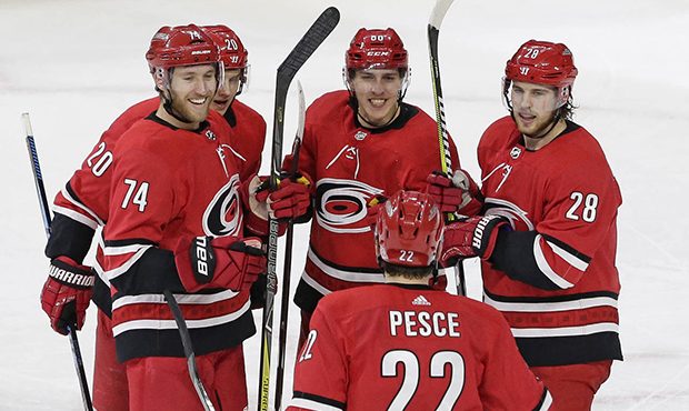 Carolina Hurricanes' Teuvo Teravainen, center, of Finland, is congratulated following his winning g...