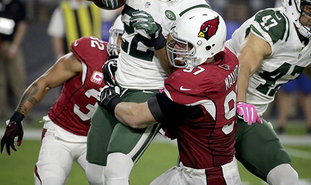 New York Jets running back Matt Forte (22) is hit by Arizona Cardinals nose tackle Josh Mauro (97) ...