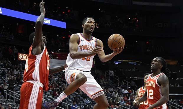 Phoenix Suns forward TJ Warren shoots while flanked by the defense of Atlanta Hawks center Dewayne ...