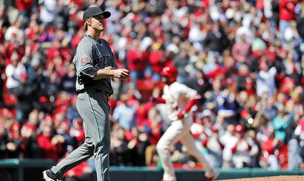 Arizona Diamondbacks starting pitcher Zack Greinke, left, walks back to the mound as St. Louis Card...