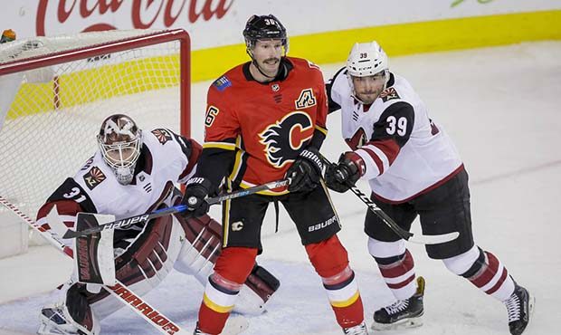 Arizona Coyotes' Joel Hanley, right, and goalie Scott Wedgewood look past Calgary Flames' Troy Brou...