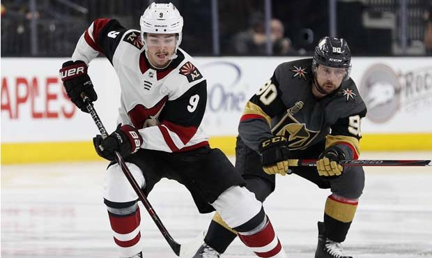 Arizona Coyotes center Clayton Keller (9) skates around Vegas Golden Knights left wing Tomas Tatar ...