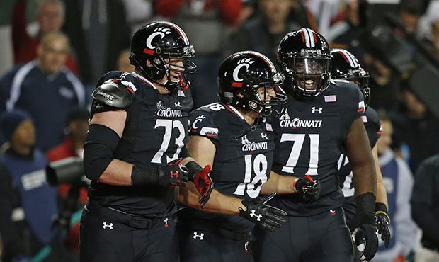Cincinnati's Ryan Leahy (73), Tyler Cogswell (18), and Korey Cunningham (71) celebrate a touchdown ...