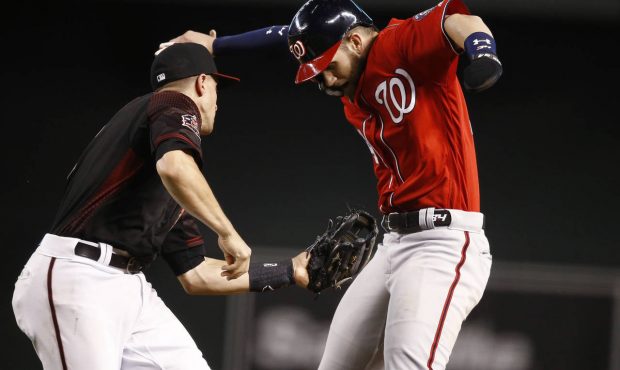 Arizona Diamondbacks shortstop Nick Ahmed, left, tags out Washington Nationals Bryce Harper in a ru...