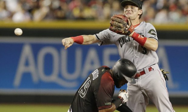 Cincinnati Reds second baseman Scooter Gennett, top, gets the force-out against Arizona Diamondback...