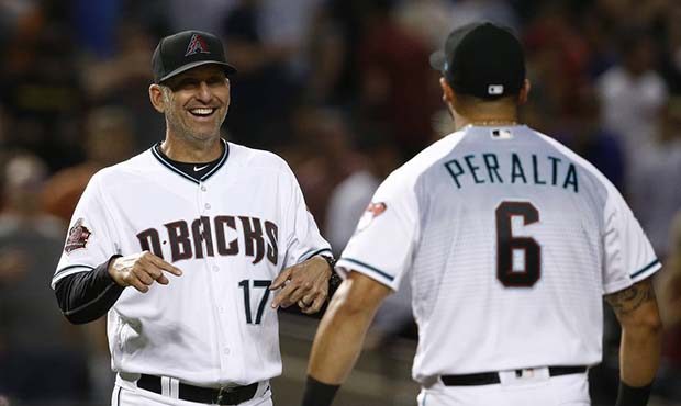 Arizona Diamondbacks manager Torey Lovullo (17) smiles as he and David Peralta celebrate the team's...