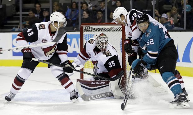 San Jose Sharks' Adam Helewka, right, collides with Arizona Coyotes' Tyler Gaudet (32) next to goal...