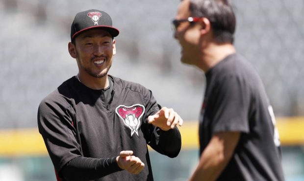 Arizona Diamondbacks relief pitcher Yoshihisa Hirano jokes with a trainer as the pitcher warms up b...