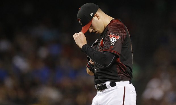 Arizona Diamondbacks starting pitcher Patrick Corbin pauses on the mound after throwing a wild pitc...