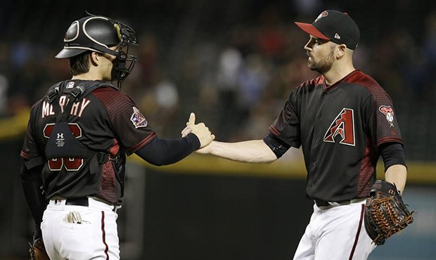 Arizona Diamondbacks relief pitcher T.J. McFarland and John Ryan Murphy (36) celebrate after defeat...