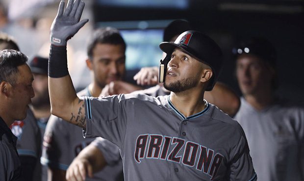 Arizona Diamondbacks' David Peralta is congratulated as he returns to the dugout after hitting a th...