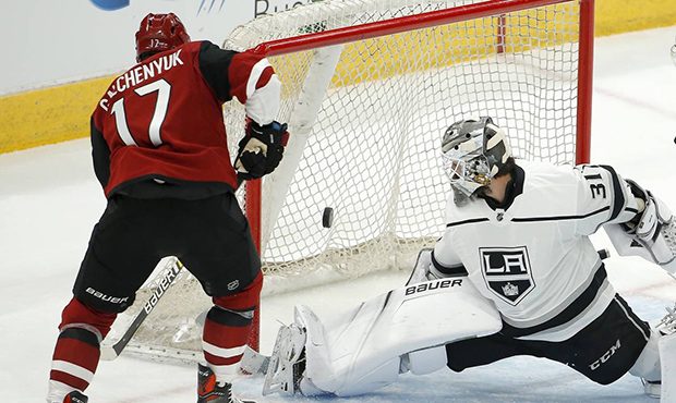 Los Angeles Kings goalie Peter Budaj (31) makes a pad save on a shot by Arizona Coyotes center Alex...