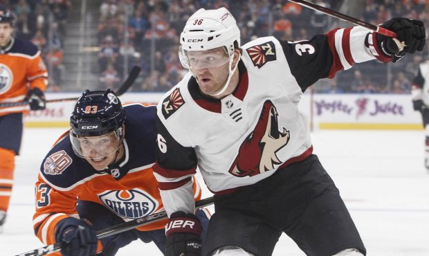 Arizona Coyotes ' Christian Fischer (36) and Edmonton Oilers' Matthew Benning (83) vie for the puck...
