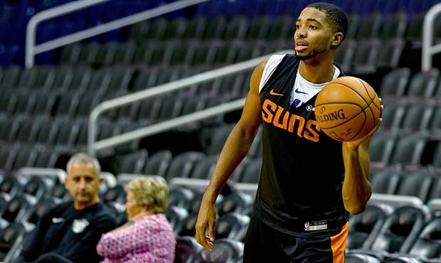 Mikal Bridges throws a pass during shootaround with Suns coach Igor Kokoškov looking on in the dis...