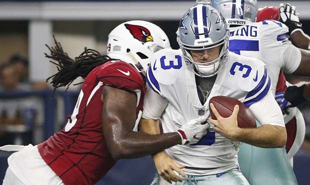 Arizona Cardinals defensive end Vontarrius Dora, left, tackles Dallas Cowboys quarterback Mike Whit...
