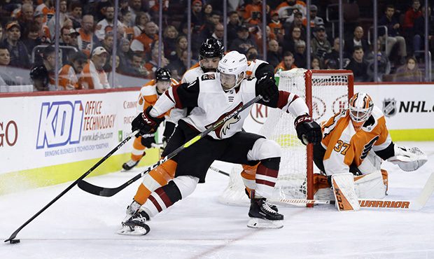 Arizona Coyotes' Brendan Perlini (11) tries to keep Philadelphia Flyers' Radko Gudas (3) away from ...