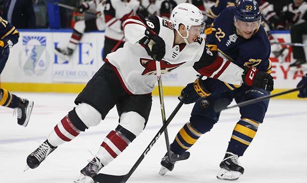 Buffalo Sabres forward Johan Larsson (22) and Arizona Coyotes forward Michael Bunting (58) battle f...
