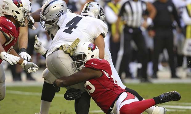 Oakland Raiders quarterback Derek Carr (4) is sacked by Arizona Cardinals defensive end Chandler Jo...