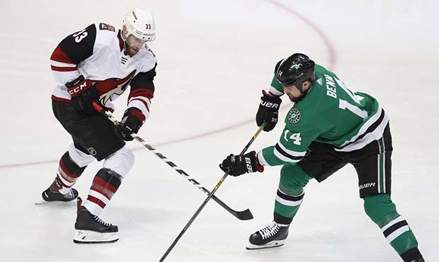 Arizona Coyotes defenseman Alex Goligoski (33) and Dallas Stars left wing Jamie Benn (14) vied for ...