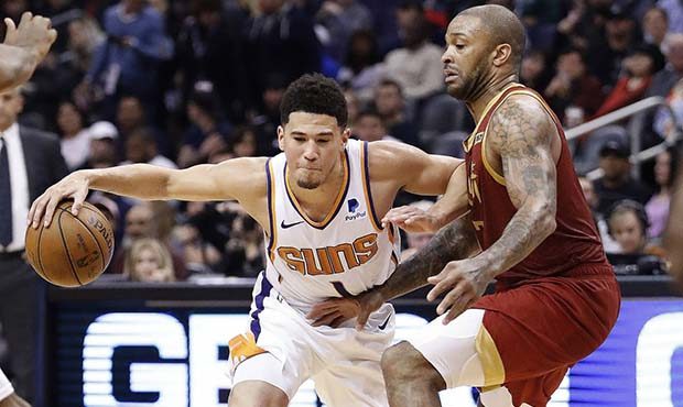 Phoenix Suns guard Devin Booker drives against the Houston Rockets forward PJ Tucker, right, during...