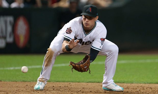 Third baseman Jake Lamb #22 of the Arizona Diamondbacks fields a ground ball against the Colorado R...