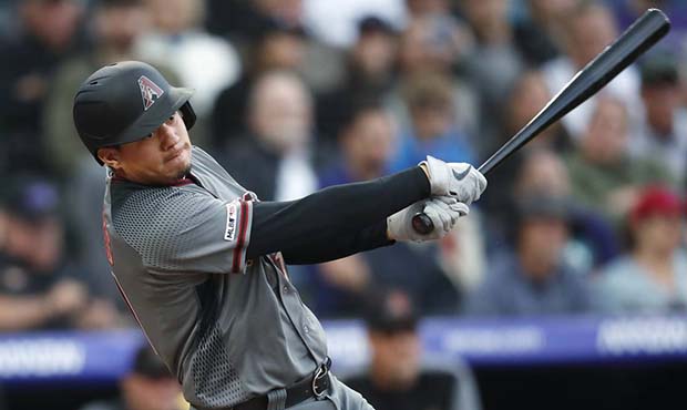 Arizona Diamondbacks' Wilmer Flores follows the flight of his RBI-double off Colorado Rockies start...