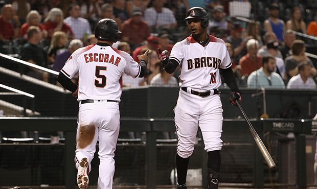PHOENIX, ARIZONA - JULY 22:  Adam Jones #10 of the Arizona Diamondbacks high fives Eduardo Escobar ...