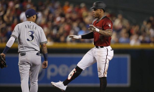 Arizona Diamondbacks' Ketel Marte, right, celebrates his double as Milwaukee Brewers shortstop Orla...