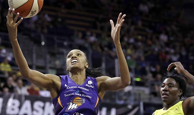 Phoenix Mercury's DeWanna Bonner, left, grabs a rebound in front of Seattle Storm's Natasha Howard ...